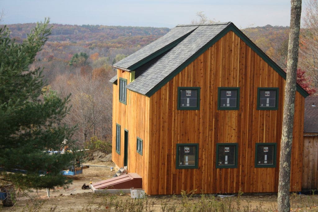 barn style home under construction with barn board siding