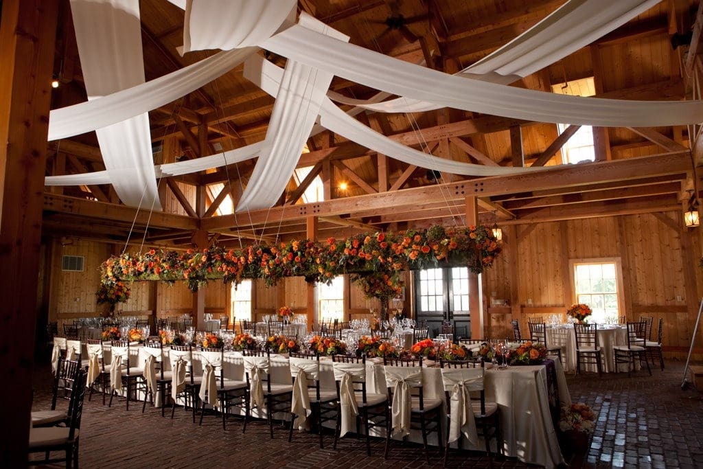elegant barn wedding dining table with orange flowers