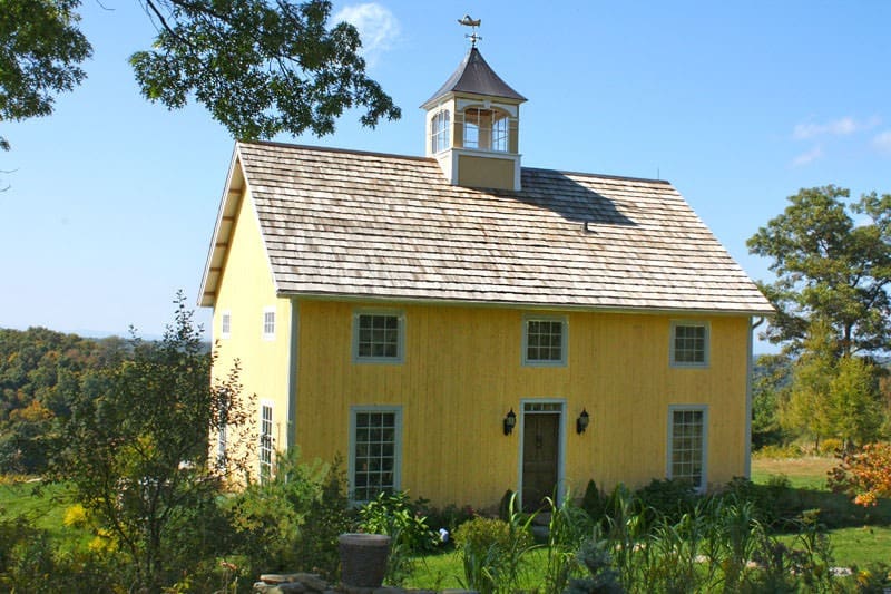 yellow barn home with cupola