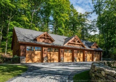 Lake Winnipesaukee, NH Retreat garage with five barn style doors and three dormers with decorative trusses.
